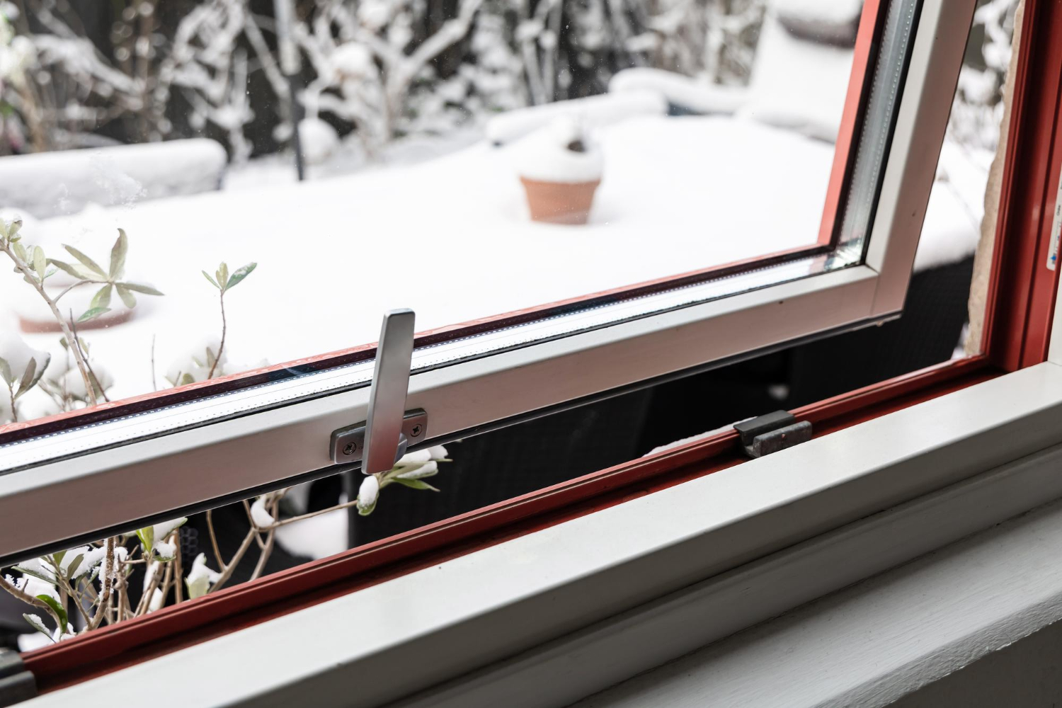 Ventana abatible de aluminio con vistas al exterior nevado